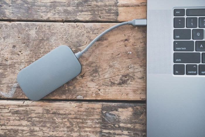 External storage drive connected to a laptop on a wooden desk